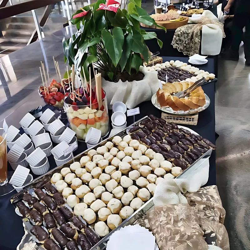 Mesa de coffee break com doces, frutas e salgados